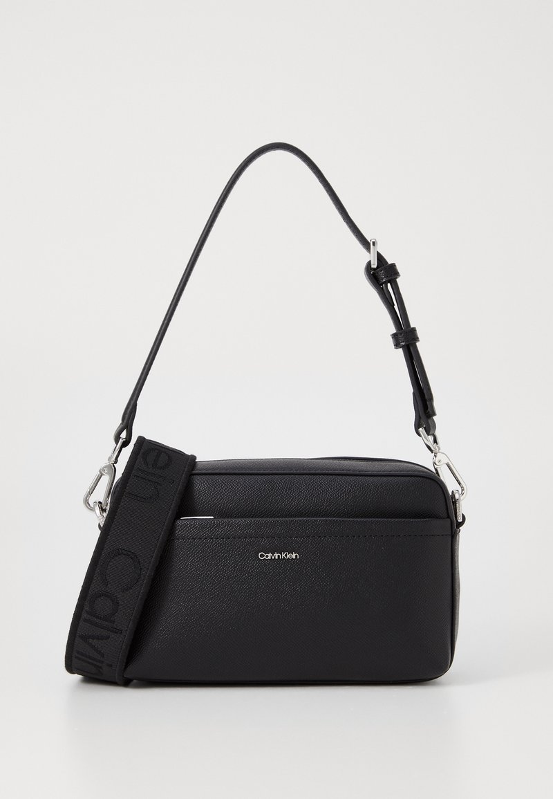 Borsa a tracolla nera in pelle testurizzata con chiusura a zip, hardware argentato e tracolla in tessuto regolabile. Dettaglio del logo sulla parte anteriore.