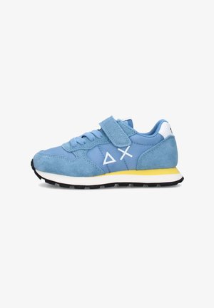 Blauwe sneaker met suède en mesh materiaal, witte geometrische logo's aan de zijkant, geel-witte zool, zwarte loopzool en klittenbandsluiting over de veters.