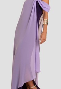 Lila Chiffonkleid mit asymmetrischen Lagen, schulterfreiem Design und fließender Silhouette. Enthält ein metallisches Armreif als Akzent.