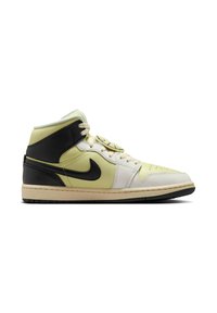 Nike mid-top tennarit, joissa on keltainen ja valkoinen nahkainen yläosa, mustalla korostetut kanta ja logo, teksturoitu pohja ja kermaiset nauhat.