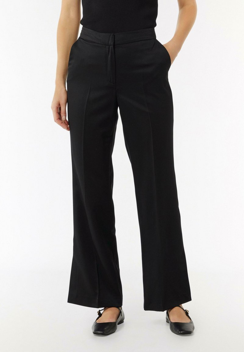 Zwarte broek met wijde pijpen, een zachte textuur, voorpanden en zijzakken. G gecombineerd met zwarte flats voor een strakke uitstraling.