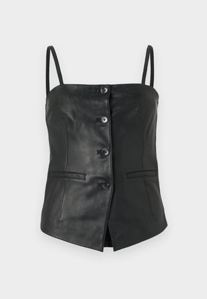 Melna bez piedurknēm ādas virsma ar četriem priekšējiem pogām, plānām siksnām un divām horizontālām kabatu atloks uz vienkrāsaina baltā fona.