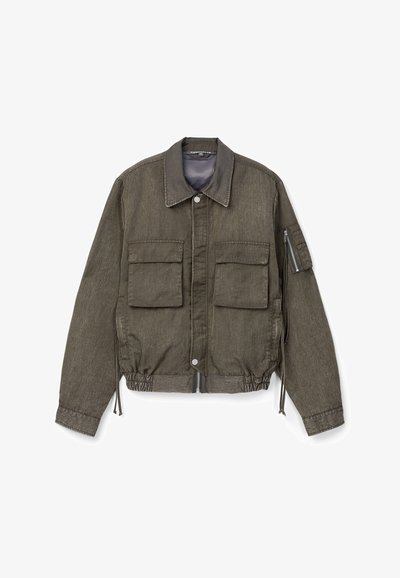 Chaqueta casual de color verde oliva con dos bolsillos frontales con solapa, bolsillo en la manga con cremallera, dobladillo elástico, cierre frontal con botones y cremallera, y cuello ancho.