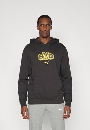 Fekete kapucnis pulóver pamut keverékből, nagy sárga "BVB 09" grafikával és egy kis Puma logóval. Elől kenguruzseb található.