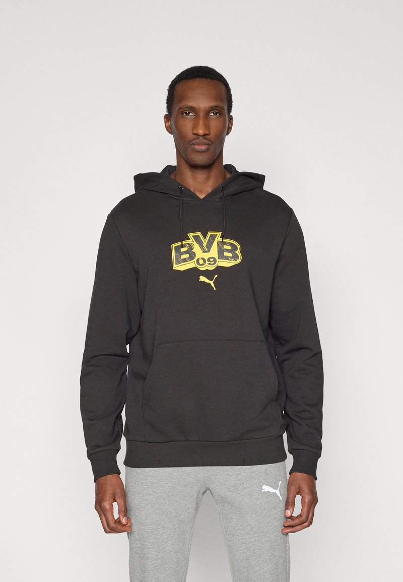Μαύρο φούτερ με κουκούλα από βαμβακερό μείγμα, με μεγάλο κίτρινο γραφικό "BVB 09" και μικρό λογότυπο Puma. Διαθέτει μπροστινή τσέπη τύπου καγκουρό.