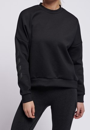 Schwarzer Pullover mit Rundhalsausschnitt, langen Ärmeln und lässiger Passform. Besitzt eine glatte Textur und drei diagonale Streifen in einer dunkleren Farbe auf dem Ärmel.