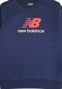 Felpa blu navy realizzata in morbido materiale, con un logo "NB" rosso e bianco in contrasto e il testo "new balance" sotto. Design classico con colletto a girocollo.