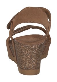 Braune Wildleder-Wedgesandalen mit einer strukturierten Korkplattform und verstellbaren Riemen, die für Komfort und Stabilität ausgelegt sind.