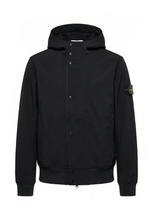 Veste noire à capuche avec boutons-pression à l'avant, poignets et ourlet côtelés, et un patch logo sur la manche gauche.