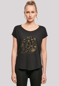 Black T-shirt with a loose fit and rolled sleeves. Features a gold graphic of Avengers characters inside a circular logo. Soft fabric texture.