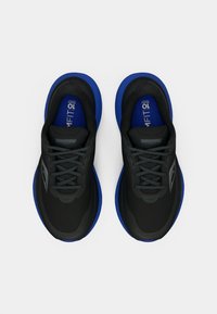 Juodos ir mėlynos Saucony bėgimo bateliai matomi iš viršaus ant baltos fono, rodančios raištelius ir ryškius mėlynus vidpadžius.