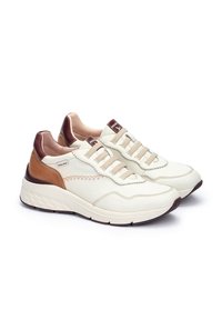 Par de zapatillas bajas en crema y marrón con cordones elásticos beige, suelas acolchadas y detalles de costura en contraste, sobre fondo blanco.