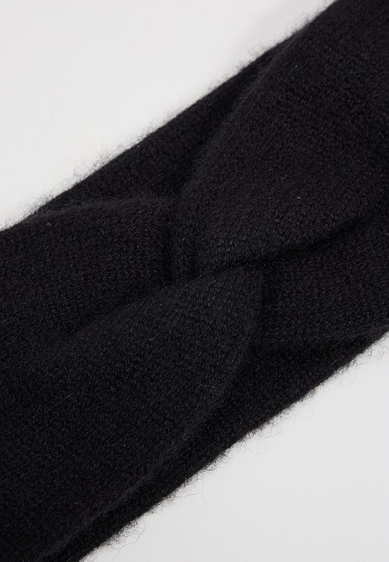 Czarna dziana opaska na głowę z twisted design. Wykonana z miękkiego, teksturowanego materiału. Gładkie wykończenie zapewnia ciasne dopasowanie, co gwarantuje ciepło.