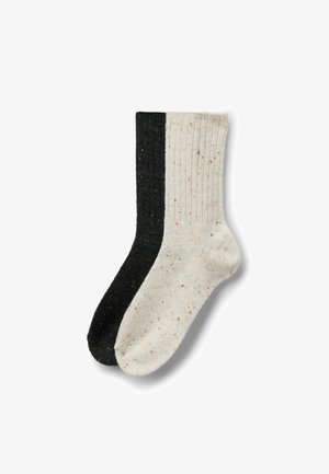 Calze a due maglie: una nera e una crema con macchie. Design a coste verticali; texture morbida; colori contrastanti creano un aspetto semplice e moderno.