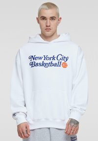 Witte hoodie met capuchon waarop "New York City Basketball" in blauwe en oranje letters staat. Bevat een voorzak en ribgebreide manchet.