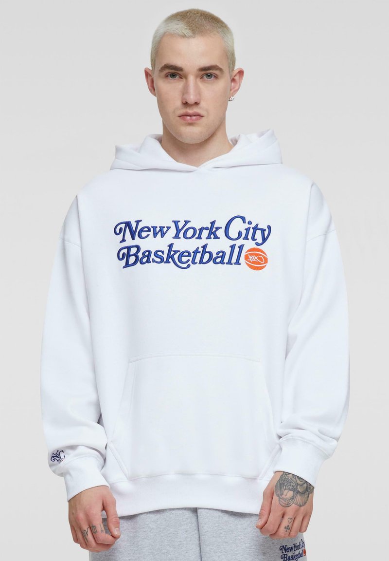 Witte hoodie met capuchon waarop "New York City Basketball" in blauwe en oranje letters staat. Bevat een voorzak en ribgebreide manchet.