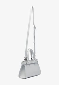 Sac à main gris clair au format structuré, avec des poignées supérieures doubles et une bandoulière amovible. Texture en cuir lisse et quincaillerie minimale.