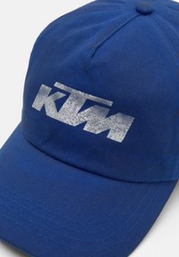 Cappello in cotone blu con logo KTM in argento. Il design presenta una visiera curva e dettagli di cucitura visibili.