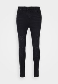 Jeans negros ajustados con detalles desgastados en las rodillas, con forma ceñida, cremallera y dos bolsillos frontales. Tejido de mezcla de algodón.