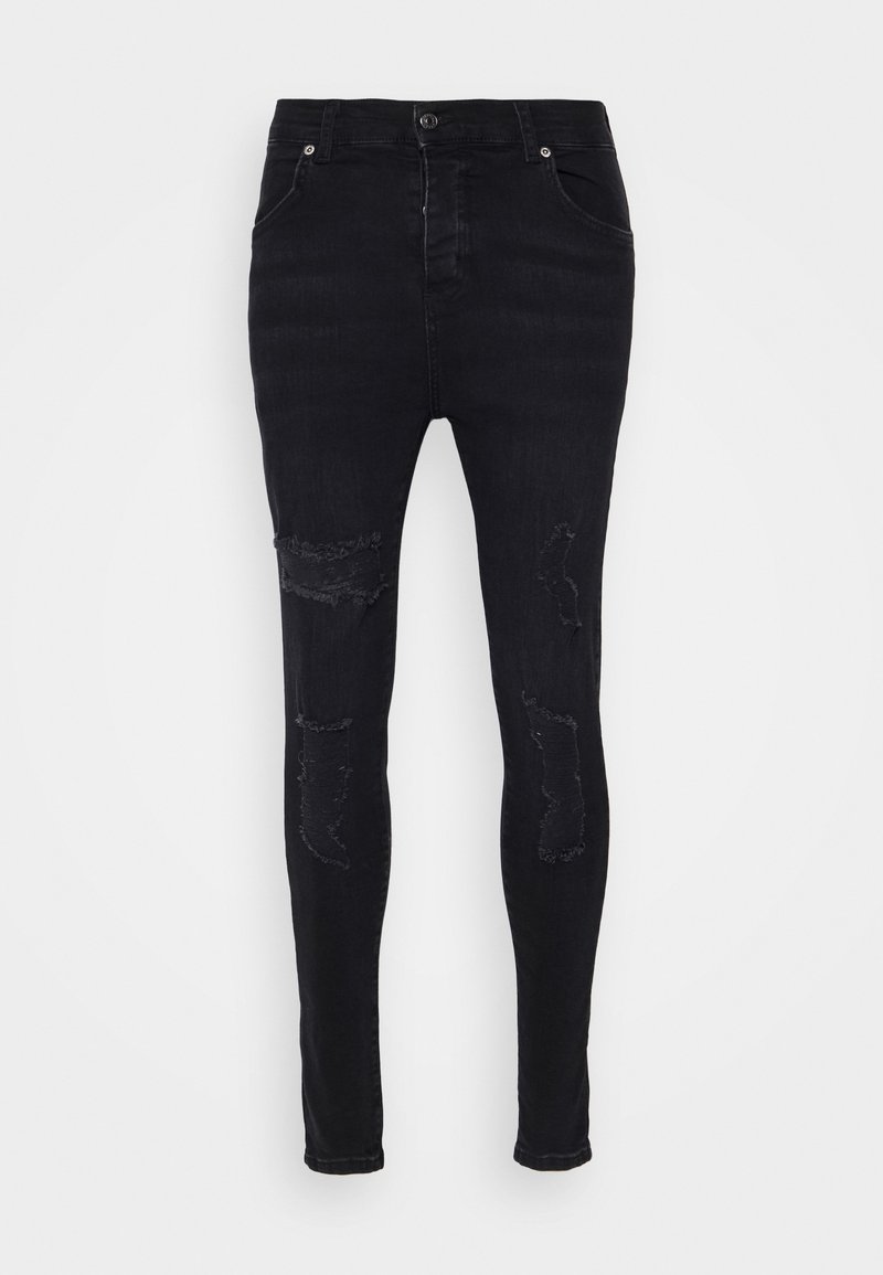 Jeans negros ajustados con detalles desgastados en las rodillas, con forma ceñida, cremallera y dos bolsillos frontales. Tejido de mezcla de algodón.
