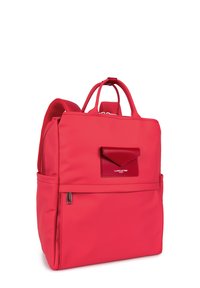 Sac à dos en nylon rouge avec une texture lisse, deux poignées supérieures, des bretelles ajustables, une poche avant et un accent de logo sur le rabat.