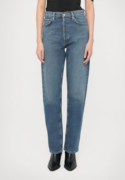Blå jeans i høj talje med straight fit. Har klassisk design med fem lommer og lukning med metal knap. Bruges med sorte støvler.