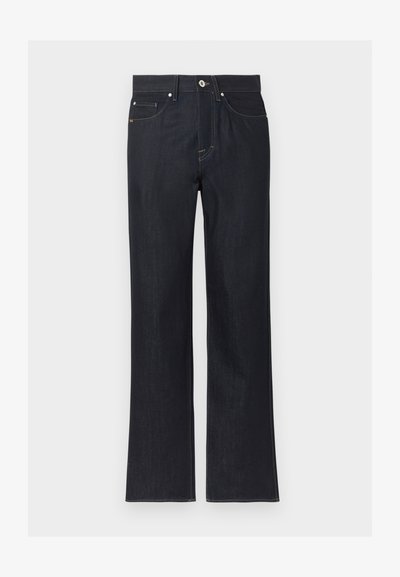 Tumesinised sirgebäärilised teksapüksid ees taskute, nööpide kinnituse ja nähtavate õmblustega lihtsal heledal taustal.