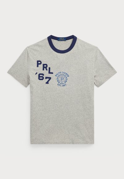 Pilkas medvilnės marškinėliai su tamsiai mėlynu šonkauliu, kuriuose išsiuvinėtas mėlynas tekstas "PRL '67" ir Ralph Lauren logotipas. Klasikinis paslaugumas, trumpomis rankovėmis.