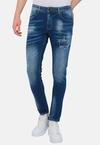 Slim-fit blauwe denim jeans met een middelmatige wassing, voorzien van versleten delen, subtiele wassing, vijf zakken, knoopsluiting en riemlussen.