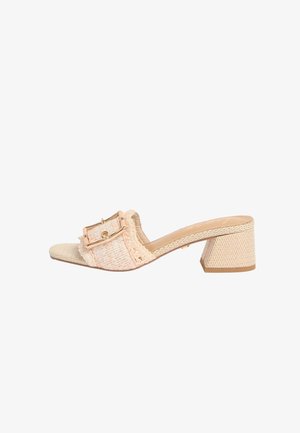 Beige vævet mule sandal med blokhæl og stor dekorativ spænde på bred frontrem.