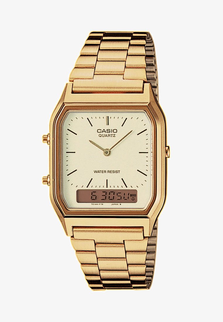 Montre quartz Casio de couleur or avec un boîtier rectangulaire, un cadran blanc, un bracelet en métal à maillons et un affichage numérique indiquant l'heure. Elle est dotée d'une fonction étanche.