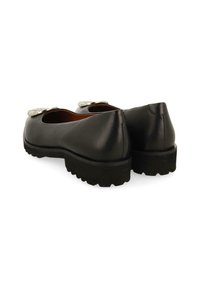 Ballerines en cuir noir avec un bout rond, présentant un accent argenté à l'avant et une semelle en caoutchouc noir texturé pour une meilleure adhérence.