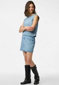 Hele sinine teksariidest komplekt, mis sisaldab varrukatuks topi ümarate kaelustega ja sobivat mini seelikut, millel on väiksed nupukesed. Mustad põlvikud.