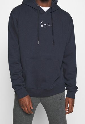 Sudadera azul marino de mezcla de algodón, con un bolsillo tipo canguro en la parte frontal, capucha con cordones y un logo bordado blanco en el pecho.