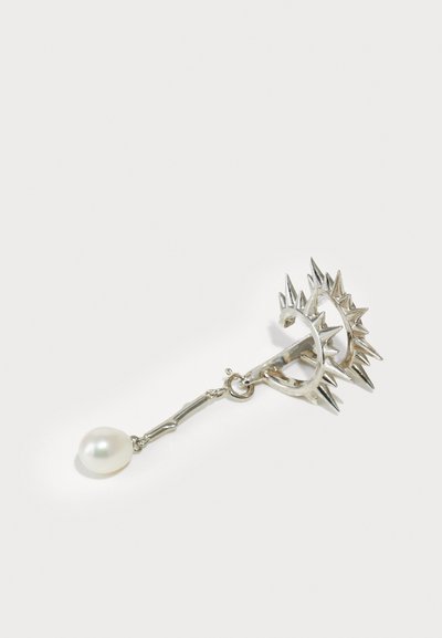 Silberne Creole mit scharfen Spitzen, einer Gliederkette und einer einzelnen weißen Perle, die am Boden hängt.