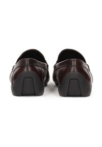 Bruine leren schoenen met een afgeronde achterkant, met een gladde afwerking en contrasterende zwarte rubberen zolen. Eenvoudig, gestroomlijnd ontwerp.
