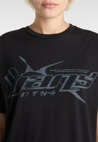 Sort bomulds-t-shirt med et slidt blåt grafisk tryk, der viser tekst og abstrakte former på forsiden. Rund halsudskæring og korte ærmer.