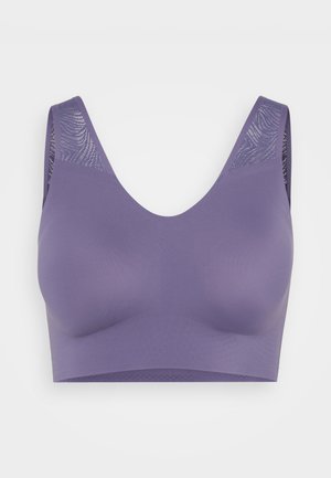 Sujetador deportivo morado con una tela suave y elástica. Presenta tirantes anchos y un panel de malla texturizada en la parte posterior. Diseño sin costuras para mayor comodidad.