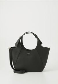 Sac à main en cuir noir avec une surface texturée, un design courbé, des poignées doubles et une bandoulière amovible. Présente un logo de marque à l'avant.