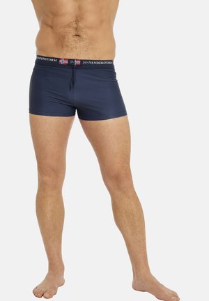 Navy blue swim trunks with an elastic waistband featuring a red, white, and blue logo. Made from a smooth, stretchy material for comfort.