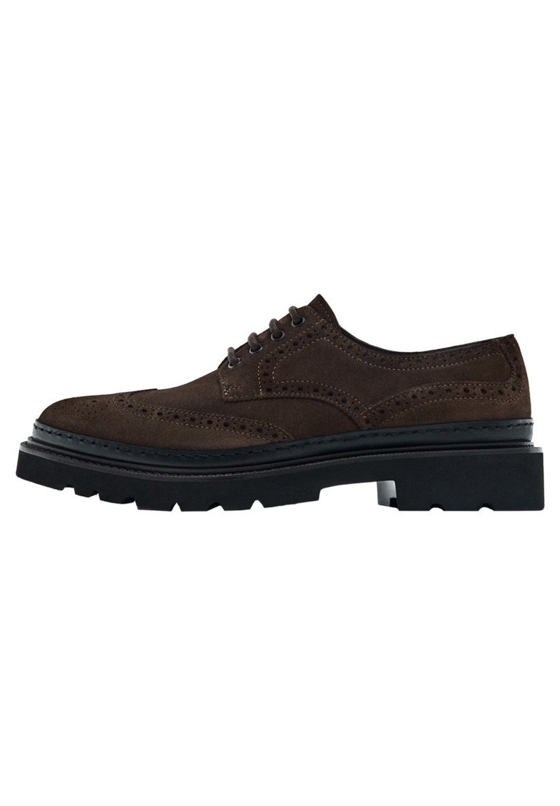 Chaussure brogue en daim marron foncé avec détails perforés, bout rond, semelle épaisse noire à crampons et fermeture à lacets à cinq œillets, vue de côté.