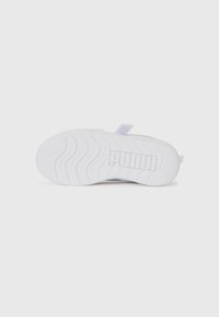 Semelle de basket blanche avec un motif en vagues, comportant un logo "PUMA" en évidence. Texture lisse, forme arrondie et légères surélévations.