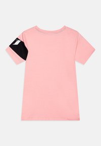 Helles rosa Baumwoll-T-Shirt mit kurzen Ärmeln, das ein schwarz-weißes Logodetail am linken Ärmel und einen runden Ausschnitt aufweist.