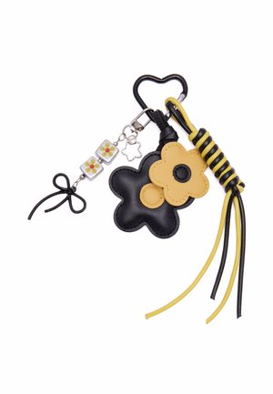 Sort og gul blomster-nøglering med hjerteformet clips, blomsterformede charms, perledetalje og knyttede snorekvaster.