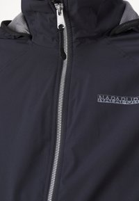 Black jacket with front zipper, high collar, and reflective Napapijri logo on the chest.