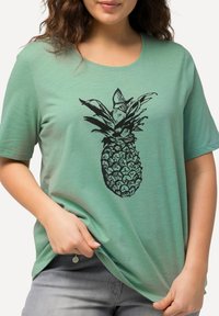 Mintgrünes T-Shirt mit kurzen Ärmeln, das ein schwarzes Ananas-Design zeigt. Weicher, leichter Stoff mit lockerem Schnitt und rundem Halsausschnitt.