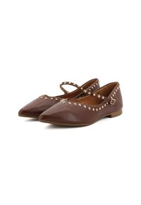 Scarpe piatte marroni con punte appuntite, decorate con borchie dorate lungo le cinghie. Presentano sottili cinturini alla caviglia e una texture in pelle liscia.