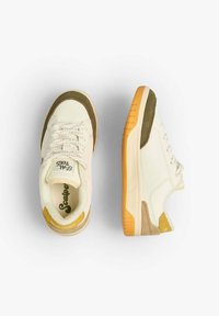 Sneaker mit einem Obermaterial aus cremefarbenem Canvas, olivgrünen Wildlederakzenten und einer gelben Gummisohle. Ausgestattet mit weißen Schnürsenkeln und einem runden Zehendesign.