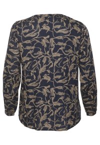 Blouse à manches longues avec un fond bleu marine et un motif floral abstrait couleur sable. Tissu léger avec une coupe décontractée et un col rond.