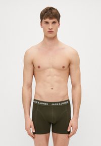 Dunkelolivgrüne Boxershorts aus weichem Stoff, mit einem weißen Gummibund und "JACK & JONES"-Logo sowie einer figurbetonten Passform.